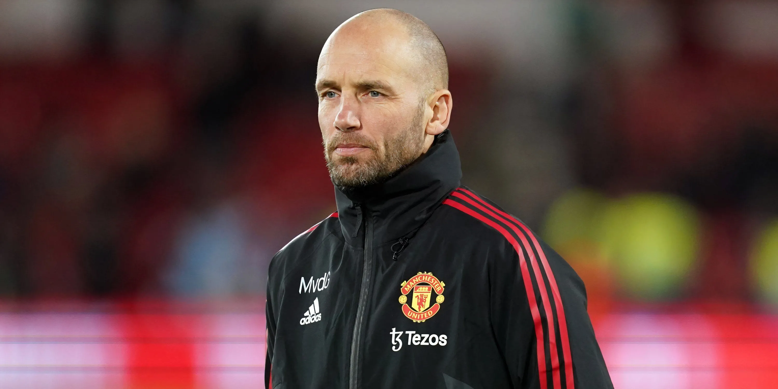 Mitchell van der Gaag trên băng ghế chỉ đạo của Manchester United, thể hiện sự tập trung cao độ trong các trận đấu của giải Ngoại hạng Anh.